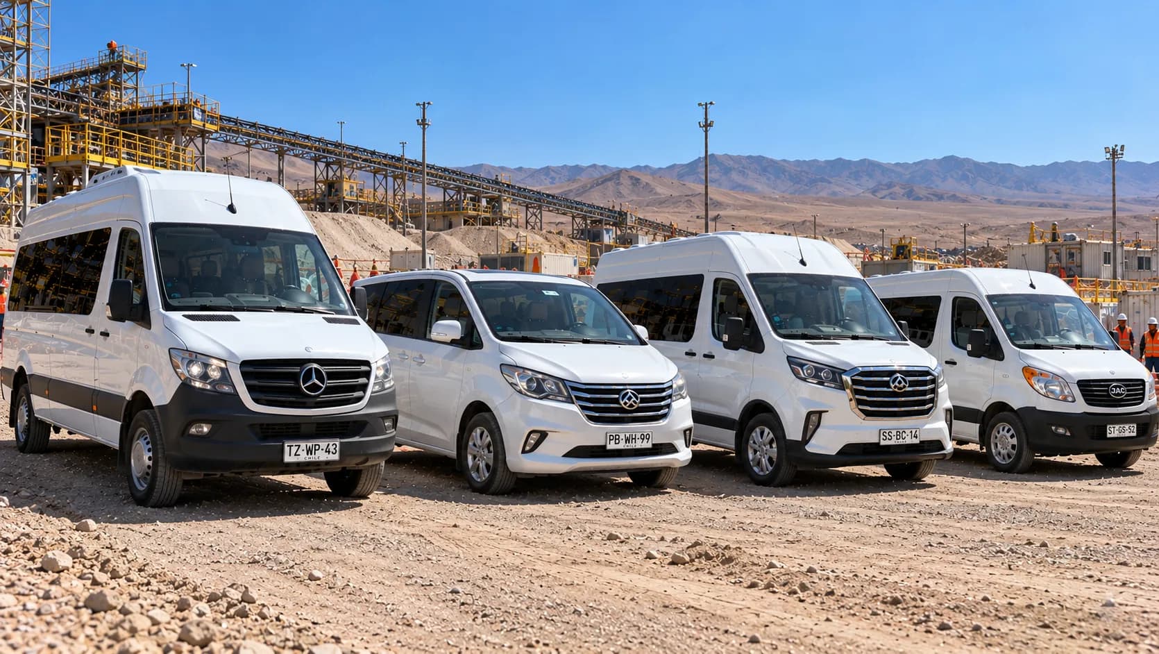 Cuatro vans blancas estacionadas en un terreno de tierra junto a una instalación industrial, con trabajadores con chaleco naranjo al fondo
